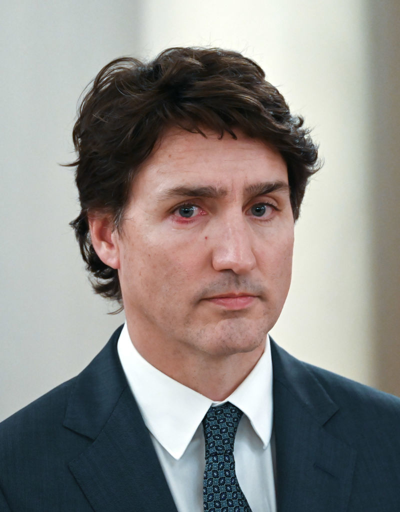 Justin Trudeau in a suit with a patterned tie, looking off to the side with a serious expression