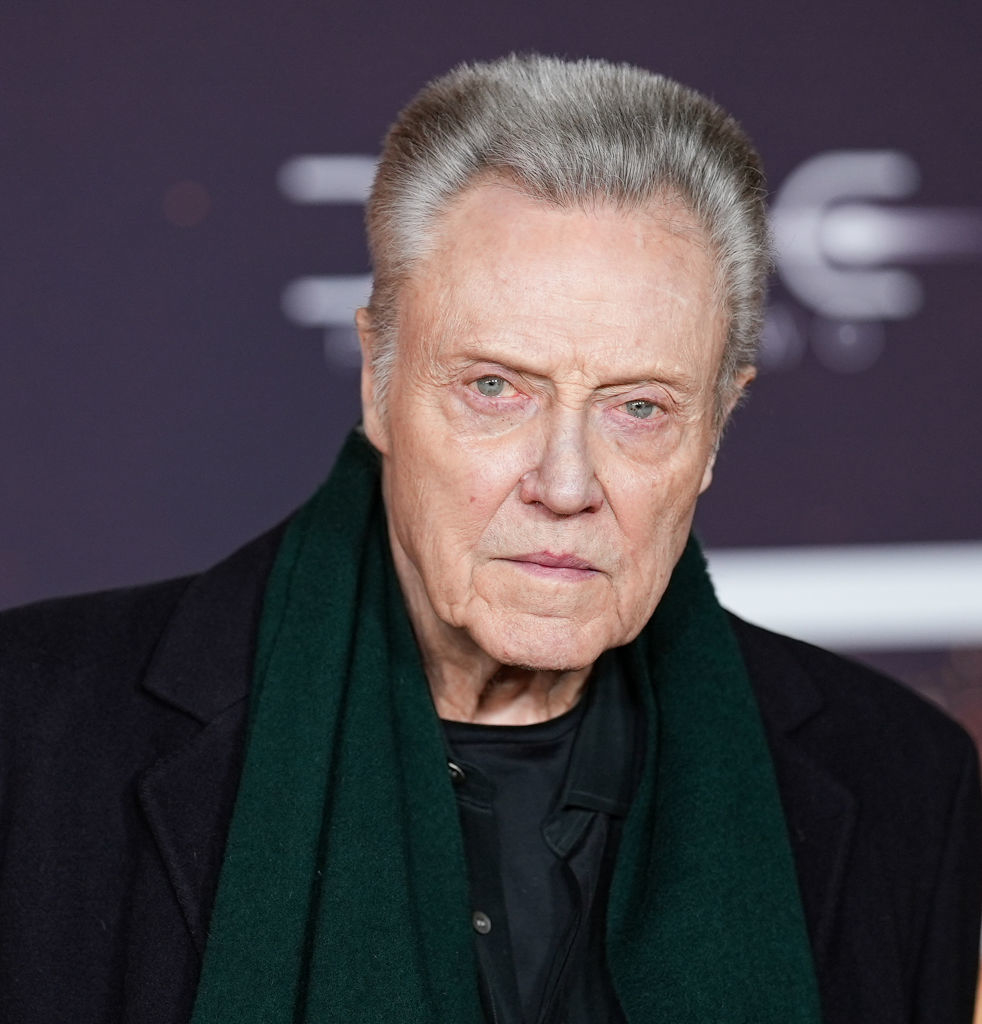 Christopher Walken in a black outfit with a green scarf on the red carpet
