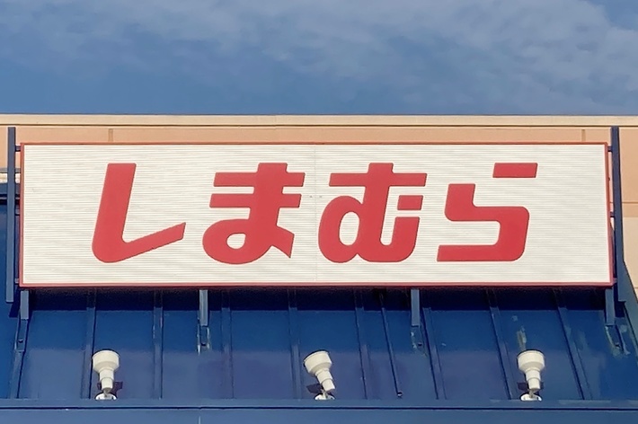 Sign with Japanese characters on a storefront under a blue sky