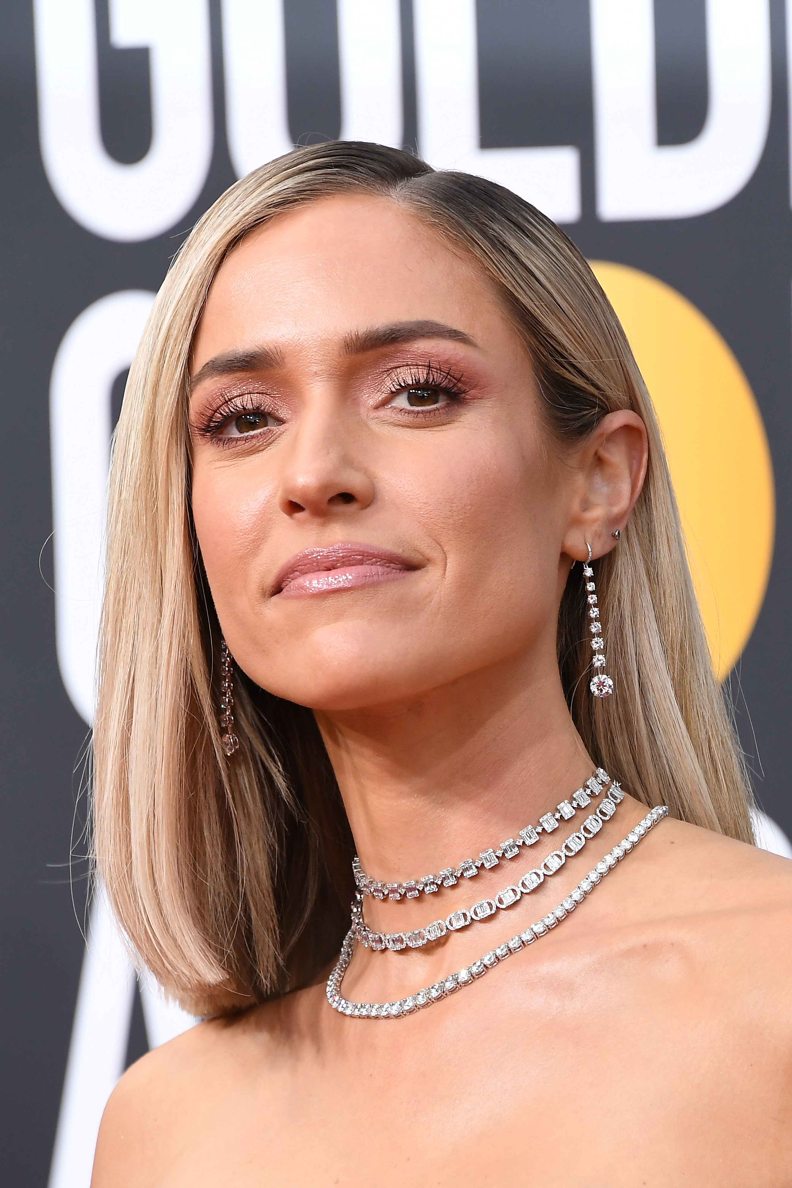 Close-up of Kristin at an event, wearing a sparkling necklace and earrings