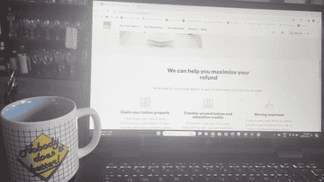 Un écran d'ordinateur portable affichant une page Web des services fiscaux, avec une tasse à café au premier plan qui contient du texte