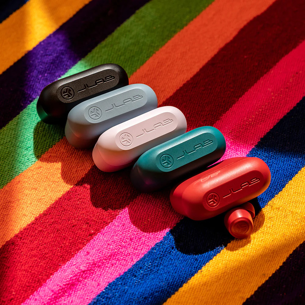 Four JLab earbud cases on a multicolored striped background