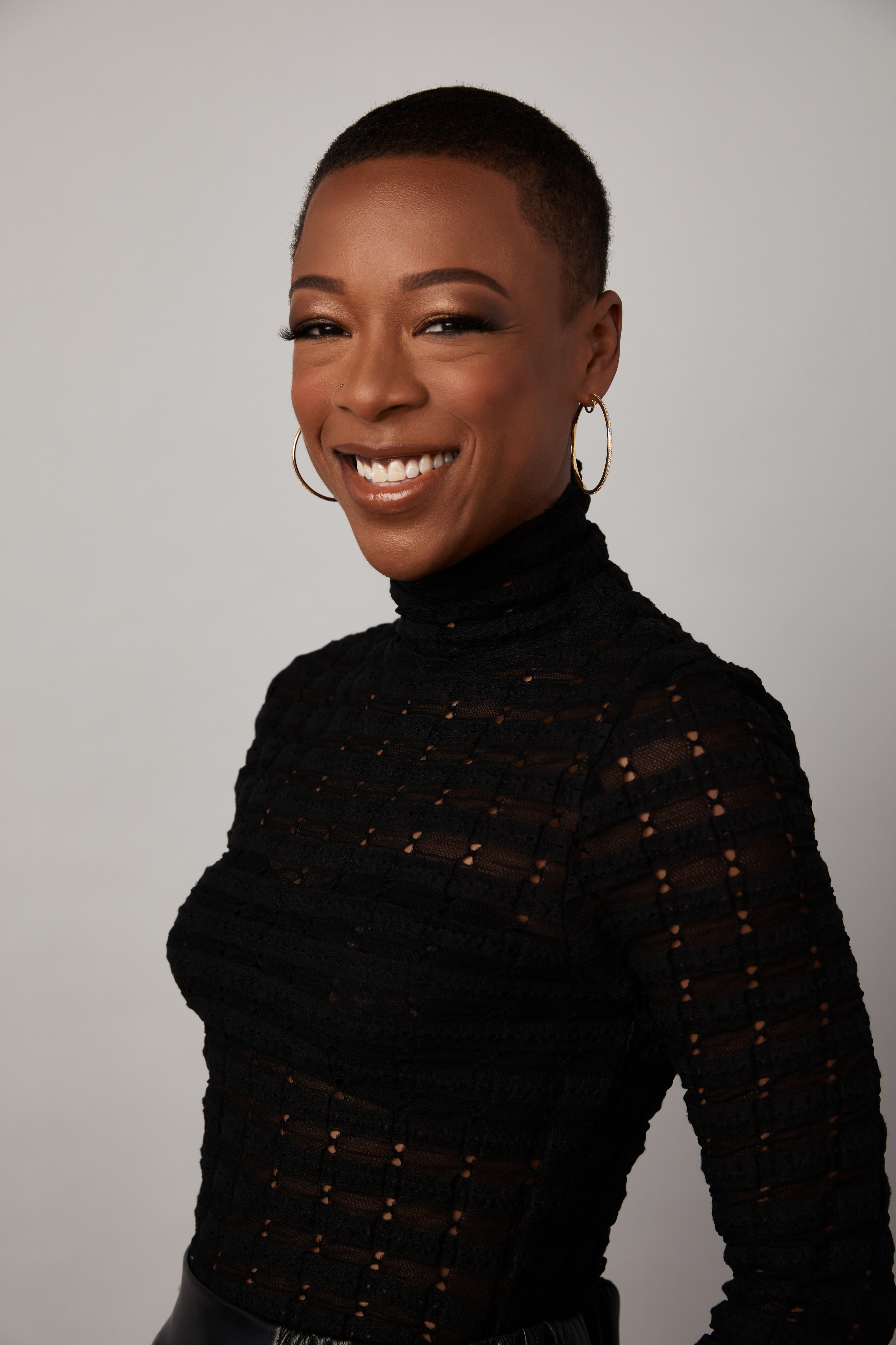 Samira Wiley in a textured top with earrings, smiling at the camera