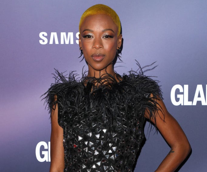 Samira Wiley in a textured dress with feather accents on the shoulders, posing at an event