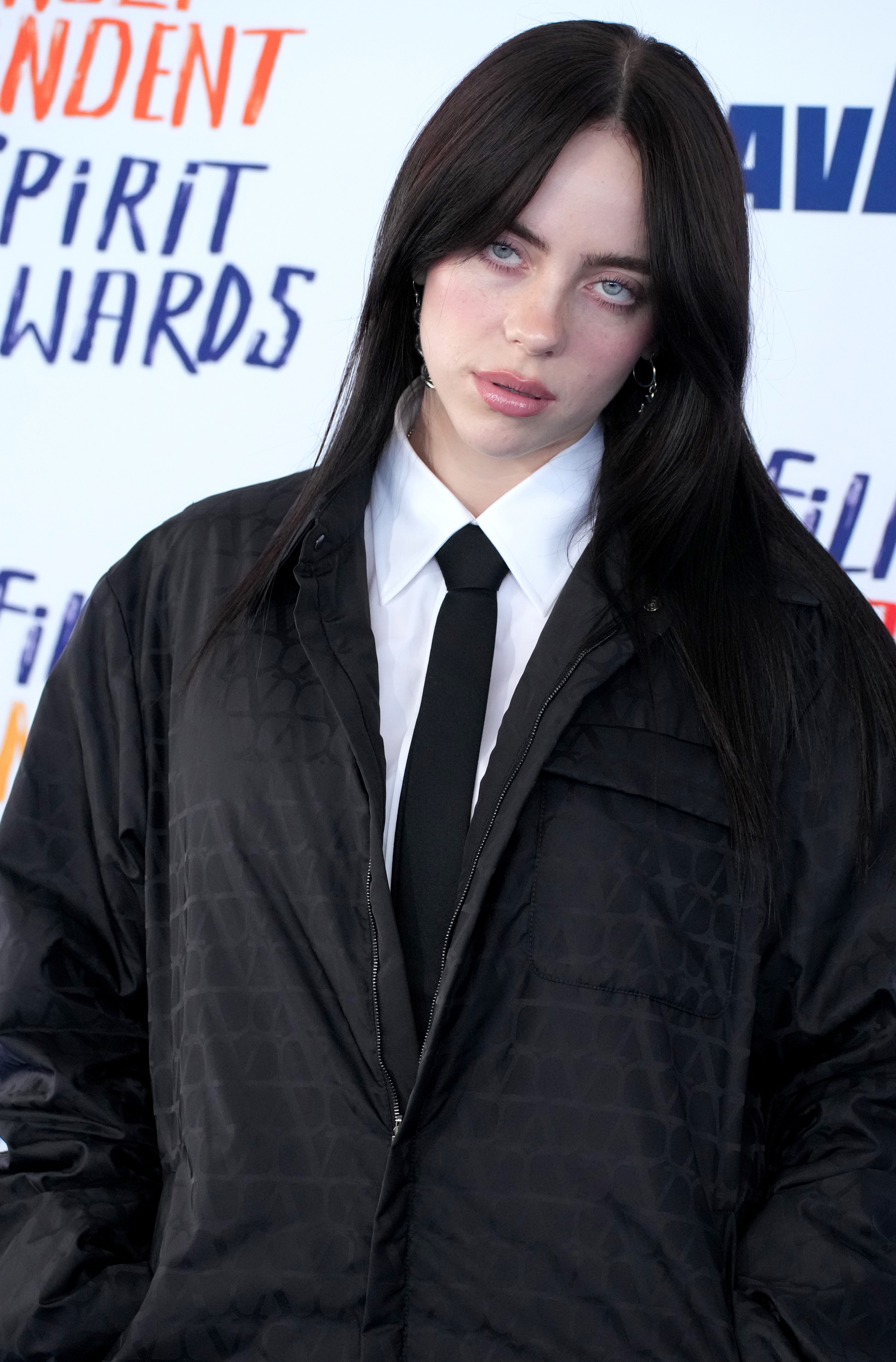 Billie Eilish wearing an oversized patterned jacket and tie at an award event