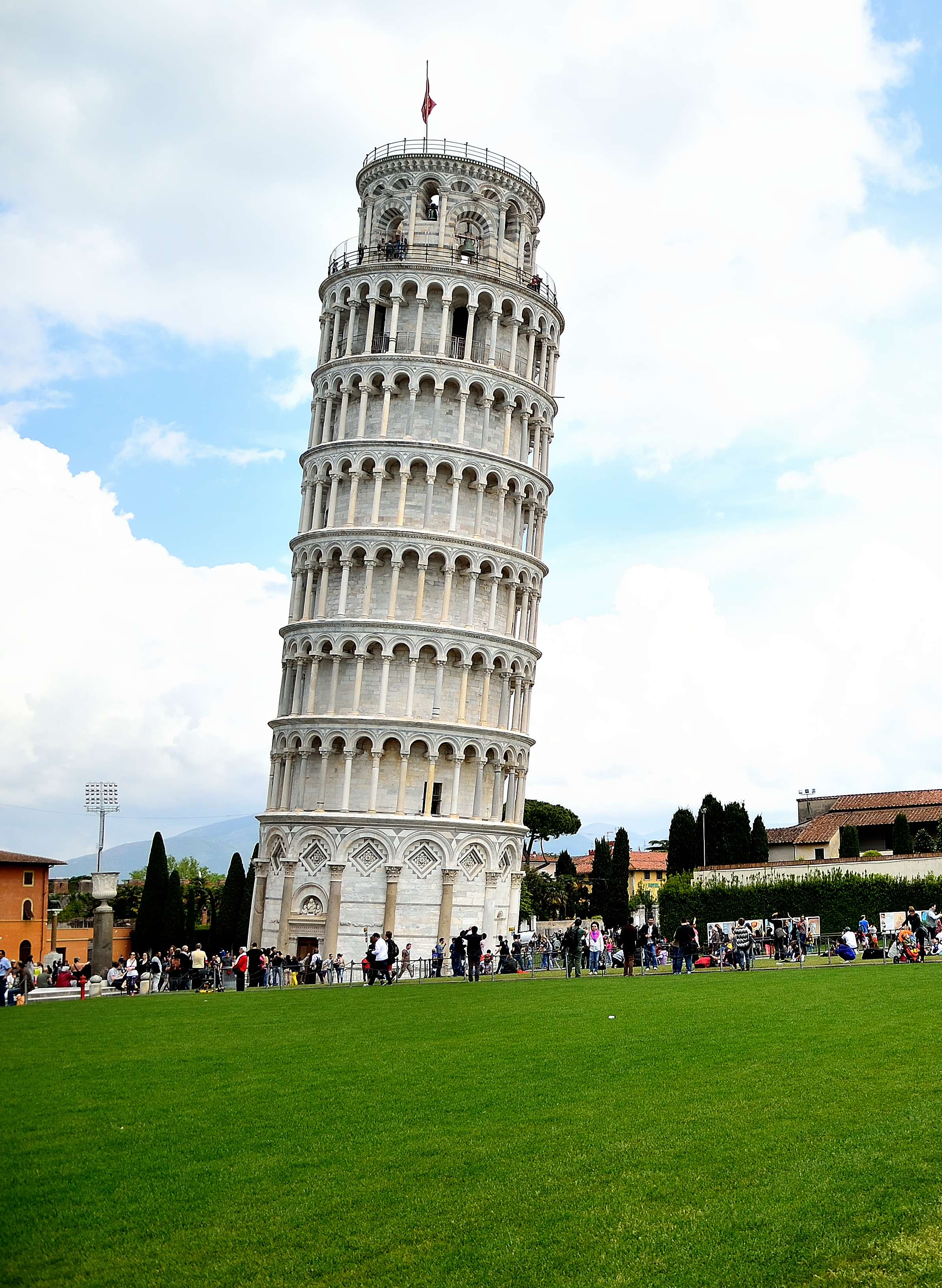 Leaning Tower of Pisa with tourists gathered around on a clear day