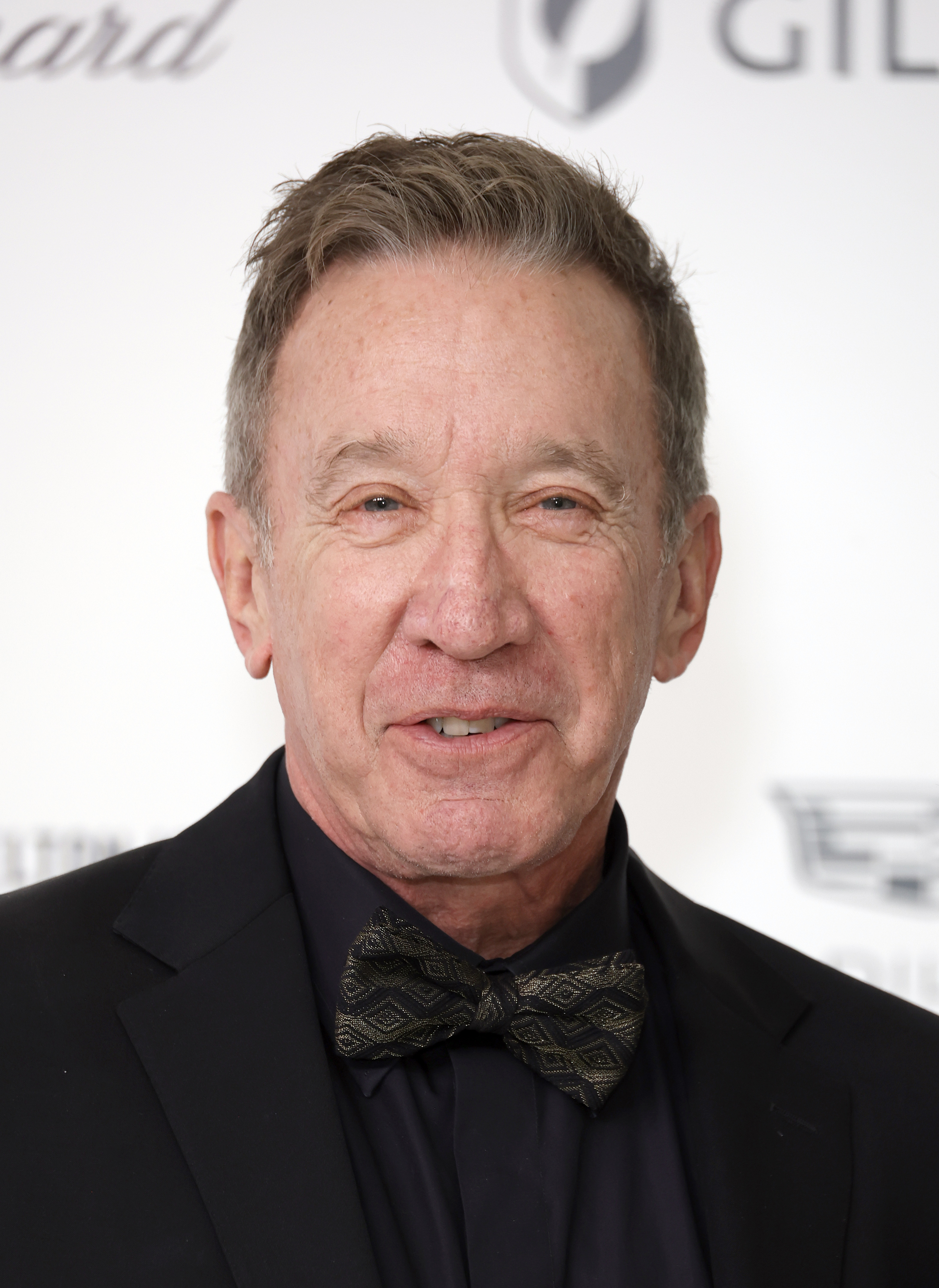 Tim Allen at an event in a black suit and patterned bow tie