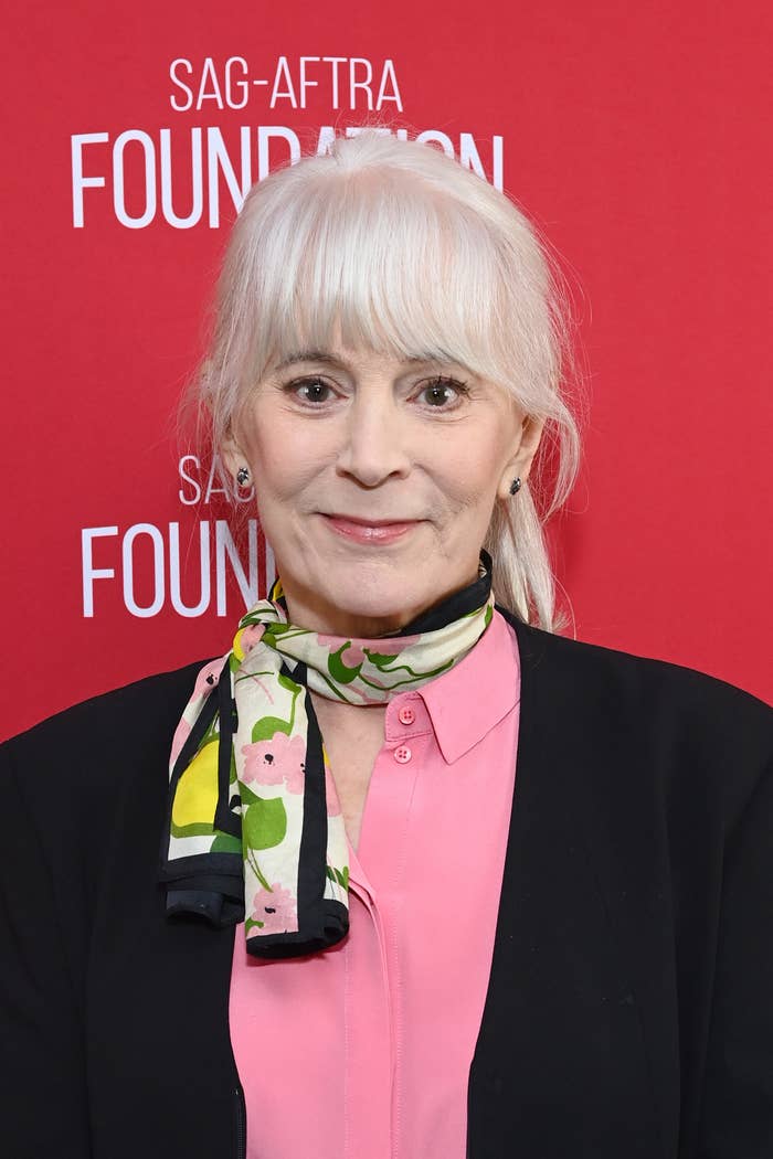 Woman with blonde hair wearing a black blazer over a pink top with a floral scarf at SAG-AFTRA Foundation event