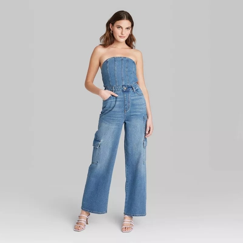Model wearing a strapless denim jumpsuit with cargo pockets