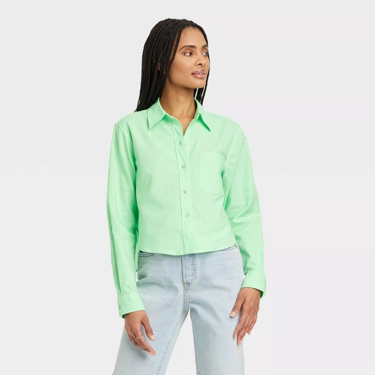 Model in a pastel green long sleeve cropped button up shirt
