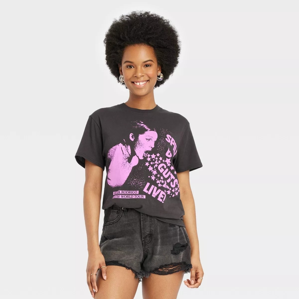 Model in a black Olivia Rodrigo t-shirt with pink illustration of Olivia on it