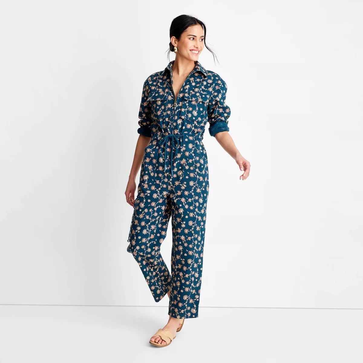Model in a dark blue boilersuit with small light colored flowers printed all over it