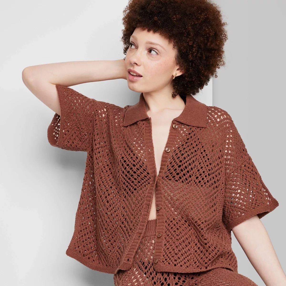 Model in a brown mesh button down short sleeve top