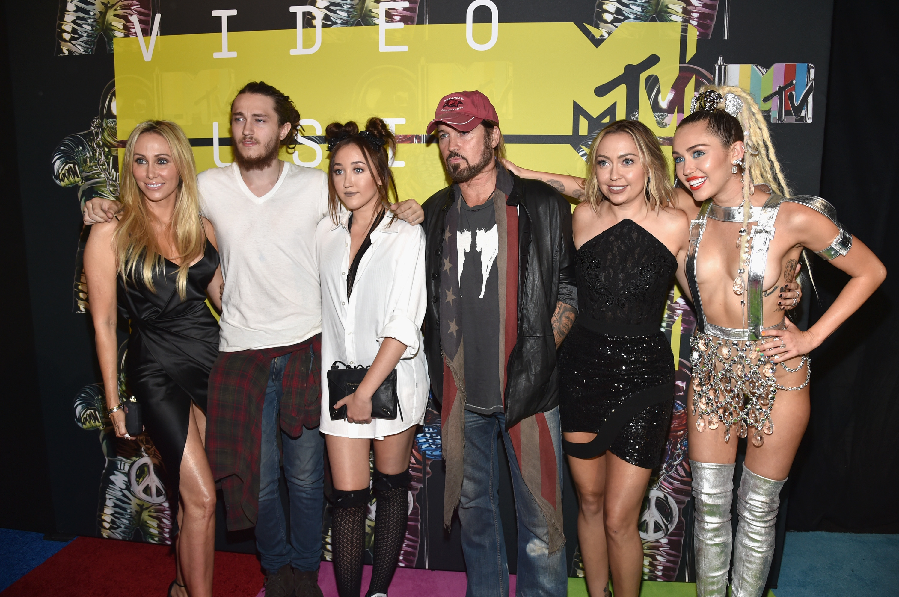 Tish and Billy Ray pose on the red carpet with several of their children