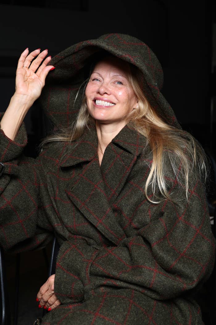 Pamela smiling and wearing a hooded plaid coat and hat