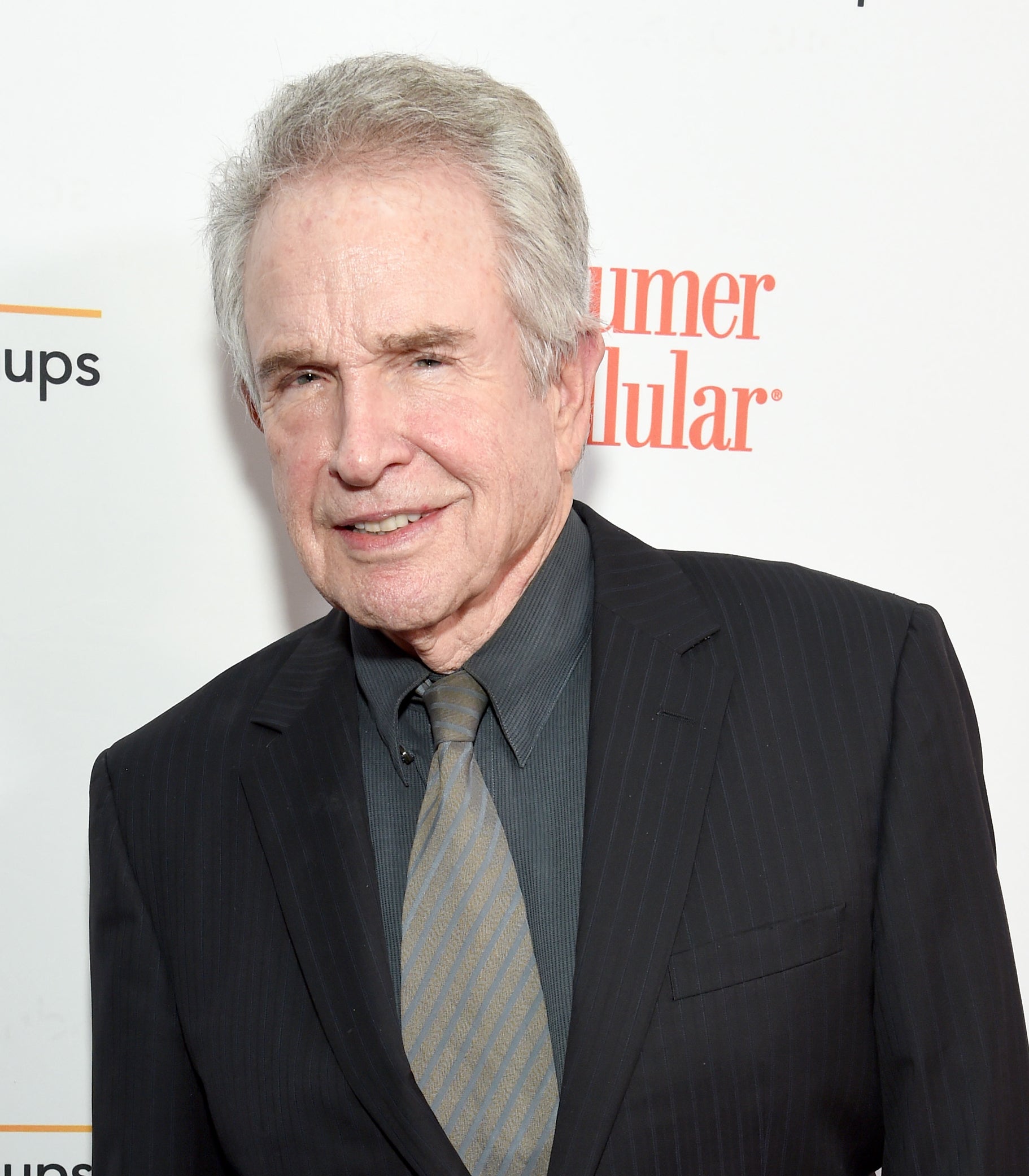 Warren Beatty in a pin-striped suit and tie at an event