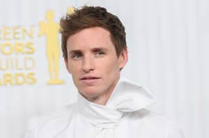Eddie Redmayne at awards event in a unique white tuxedo with large bow