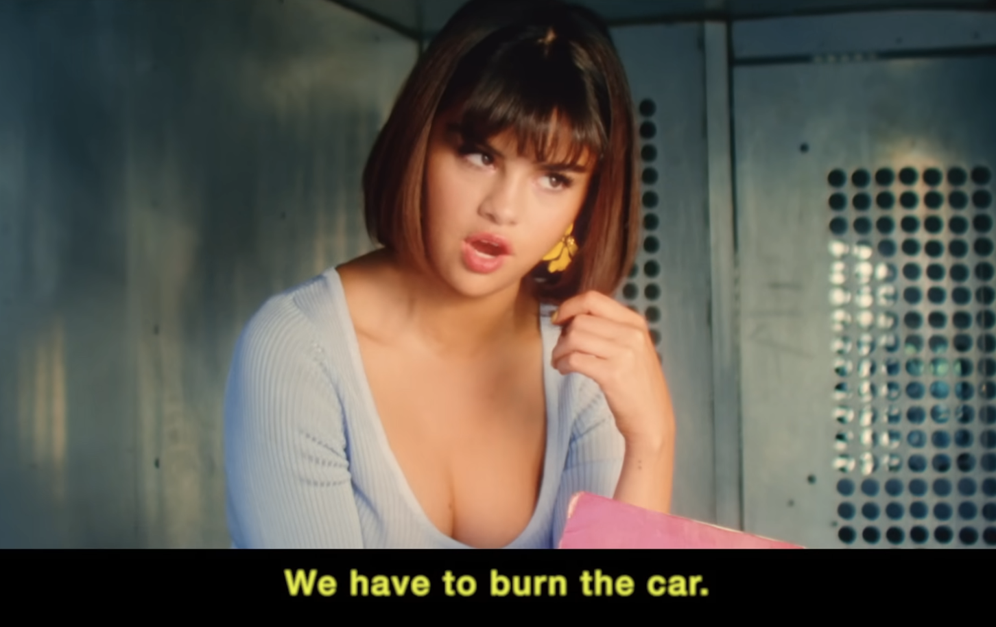 Selena Gomez in a music video scene, leaning against a car window with a vintage aesthetic