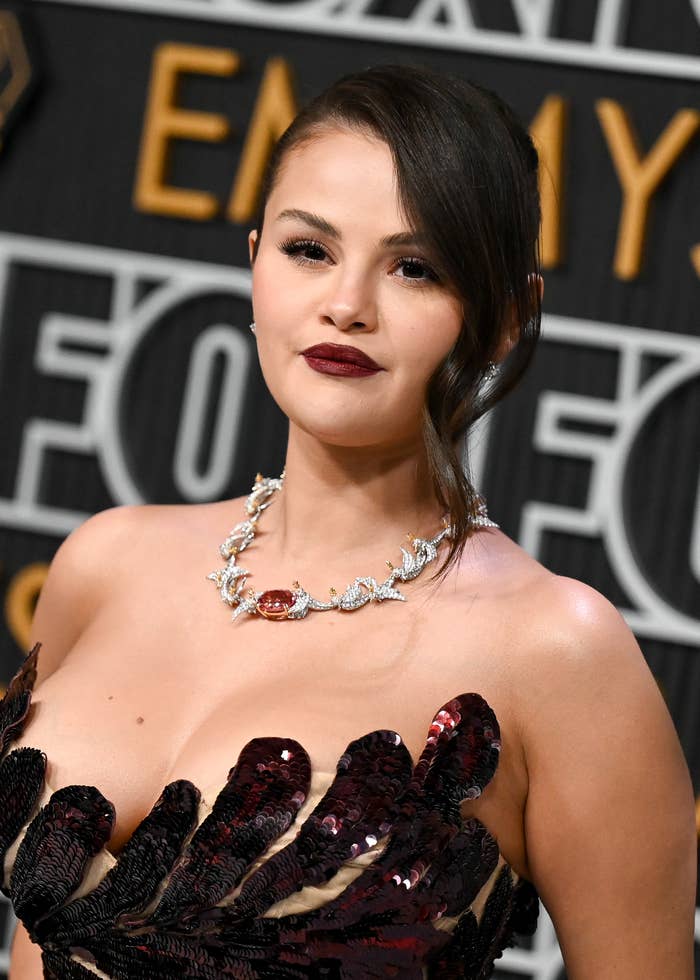 Selena Gomez wearing a sequined strapless dress and statement necklace at an event