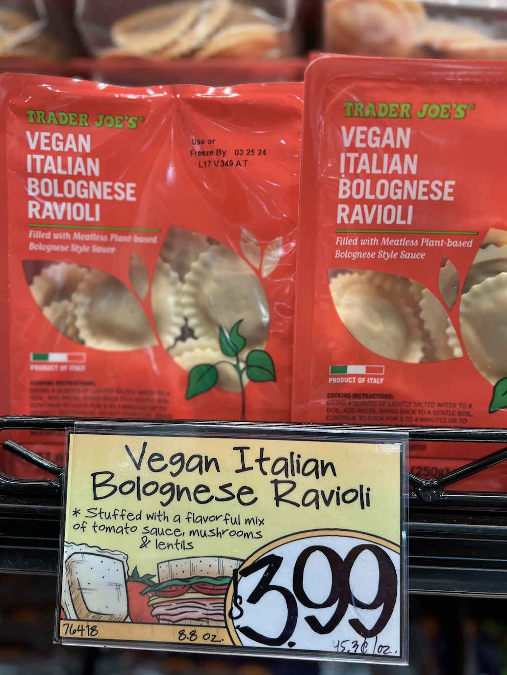 Packages of Trader Joe&#x27;s Vegan Italian Bolognese Ravioli on a shelf with a price tag of $3.99 below