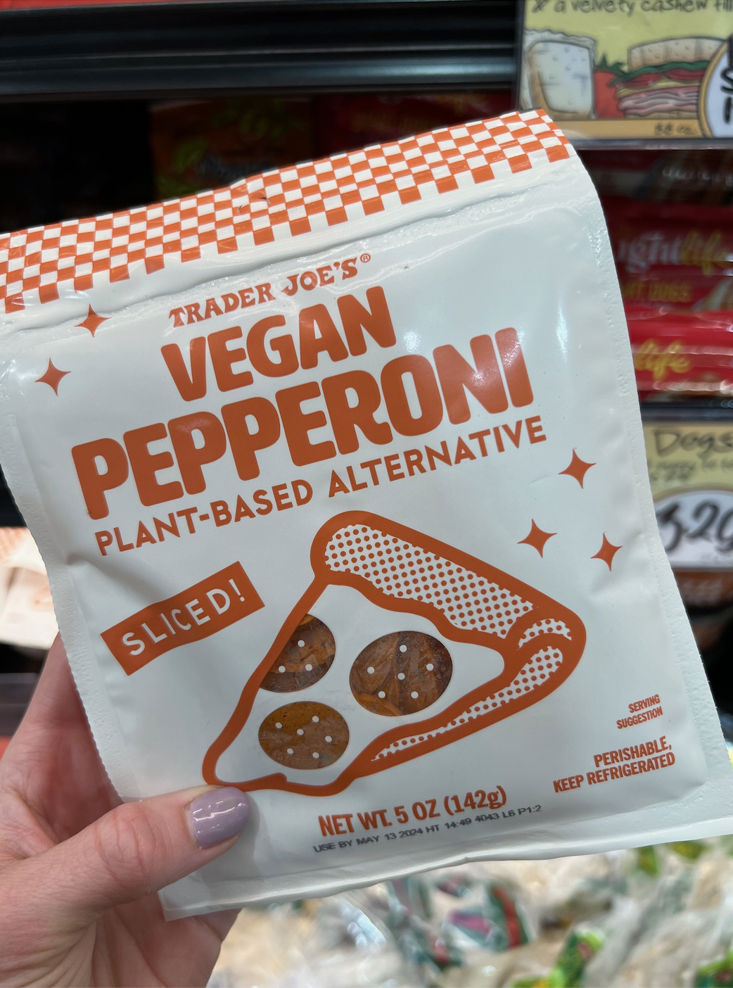 Hand holding a package of Trader Joe&#x27;s Vegan Pepperoni plant-based alternative slices