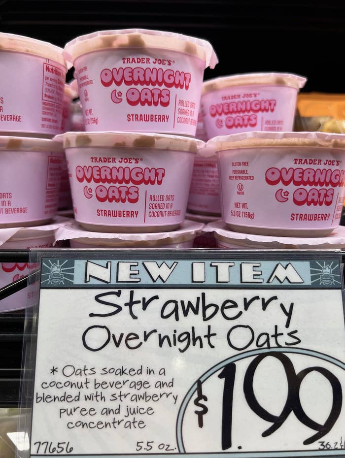 Shelves stocked with containers of Trader Joe&#x27;s new strawberry overnight oats, with a price tag in the foreground