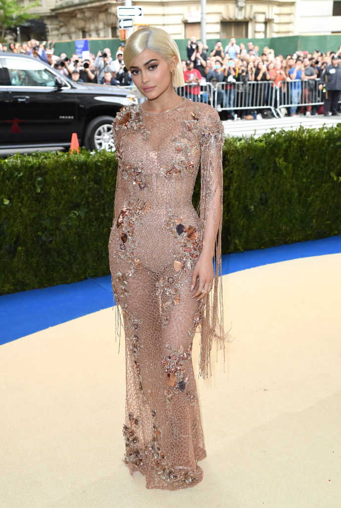 Kylie Jenner in a sheer, embellished gown with fringe details at a red carpet event