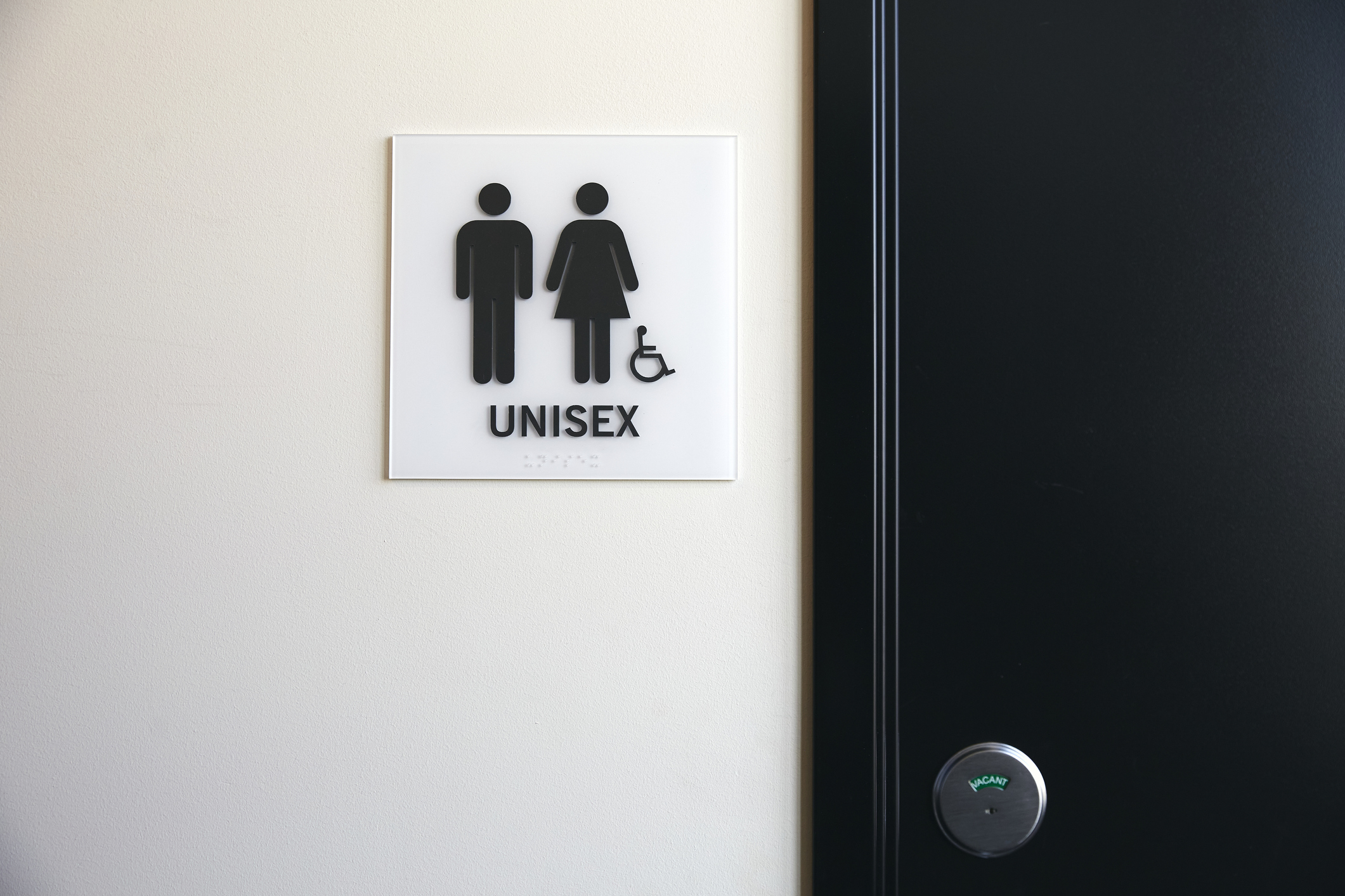 Unisex bathroom sign with symbols for all genders and accessibility feature