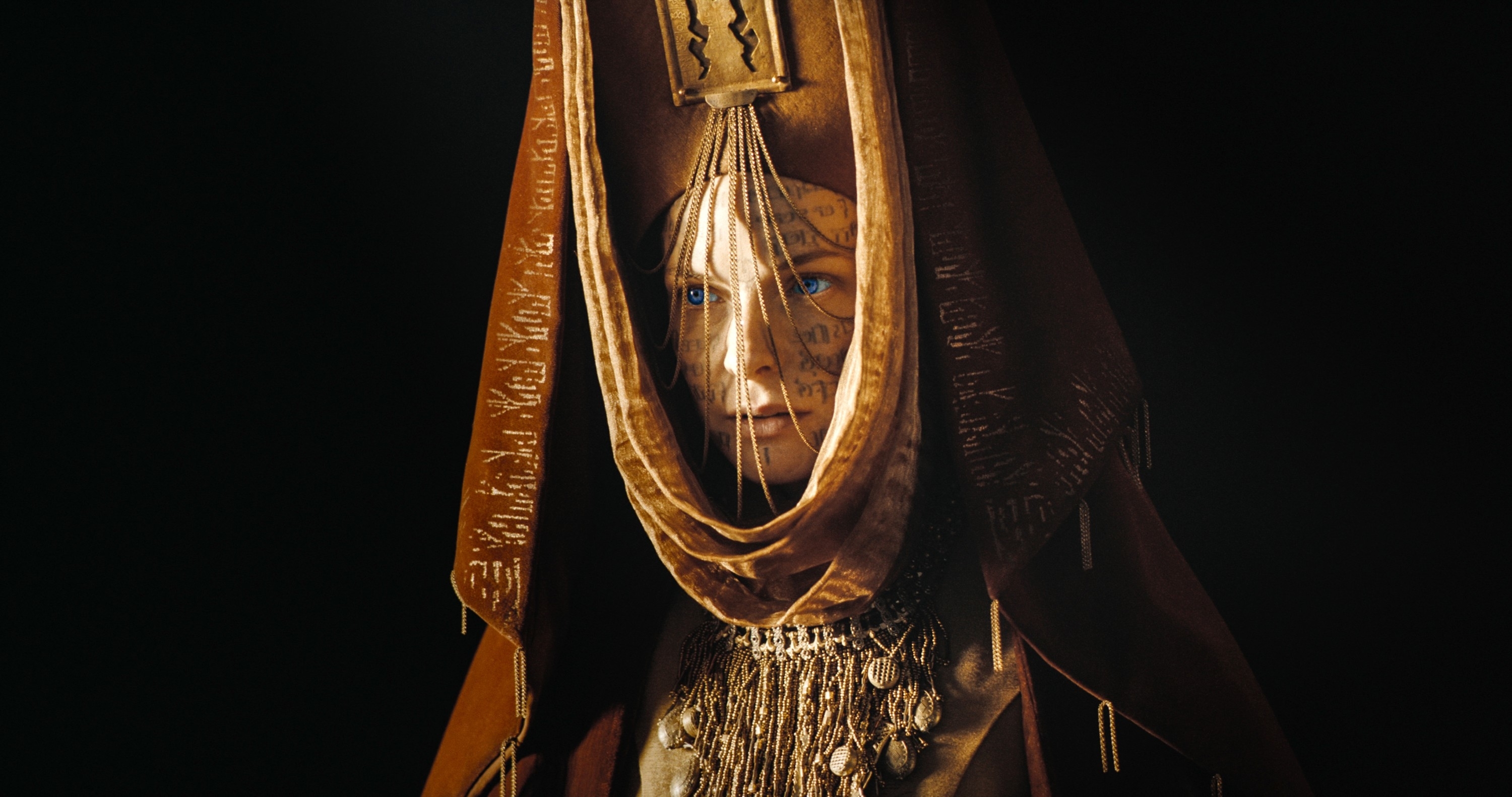 Rebecca as Lady Jessica in an ornate costume with facial tattoos, draped in a hooded cloak, from the TV show