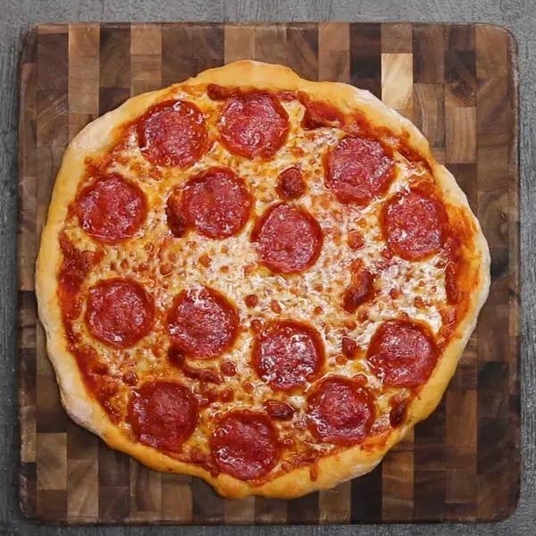 Pepperoni pizza with melted cheese on a wooden board