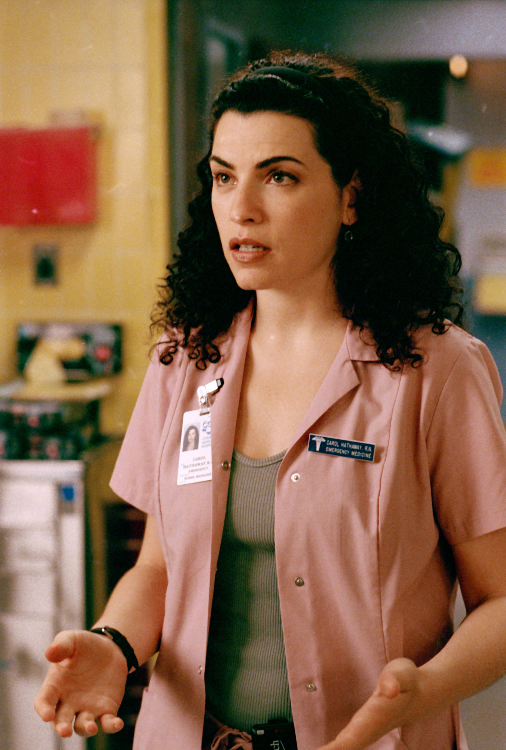 Julianna Margulies as Nurse Carol Hathaway in a scene from the TV show &quot;ER,&quot; wearing scrubs and a badge
