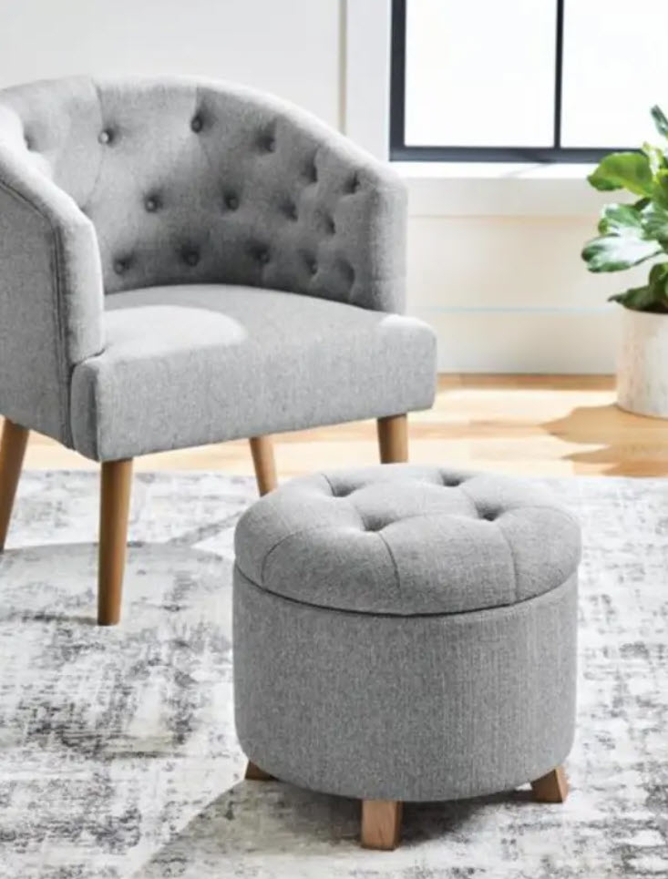 Grey tufted armchair with matching ottoman in a bright room