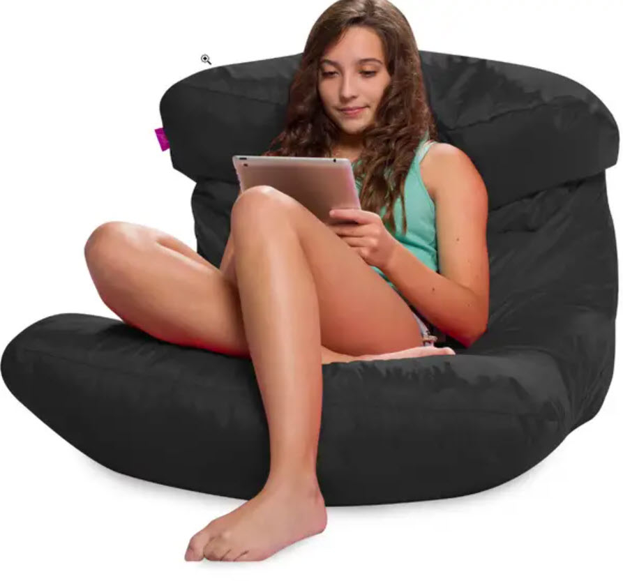 Person sitting on a black bean bag chair using a tablet