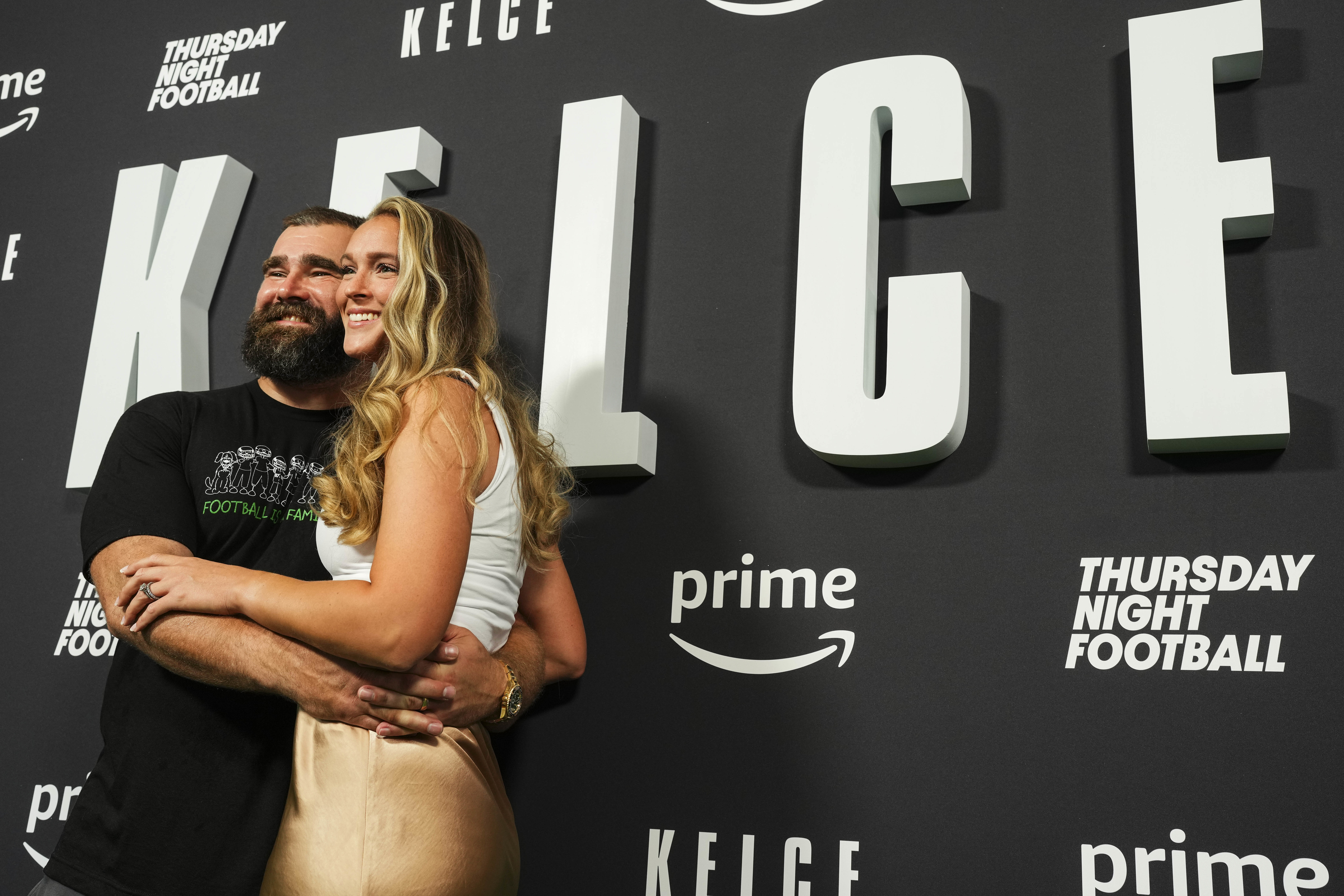 Jason and Kylie Kelce embracing and smiling at a Thursday Night Football event