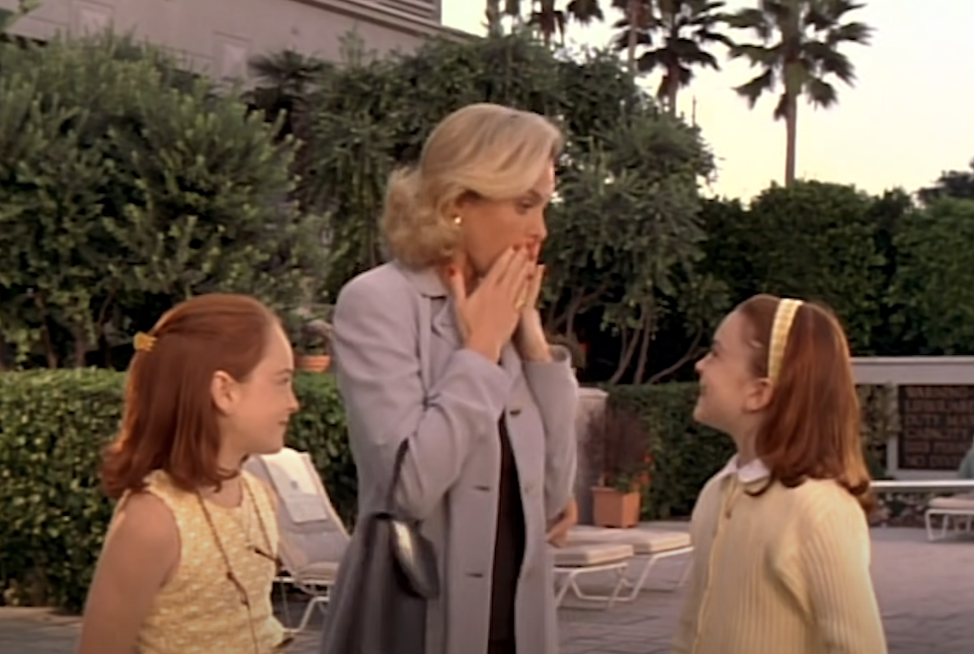 Annie and Hallie watch their mother, dressed in a suit, react with surprise, in &#x27;The Parent Trap&#x27;