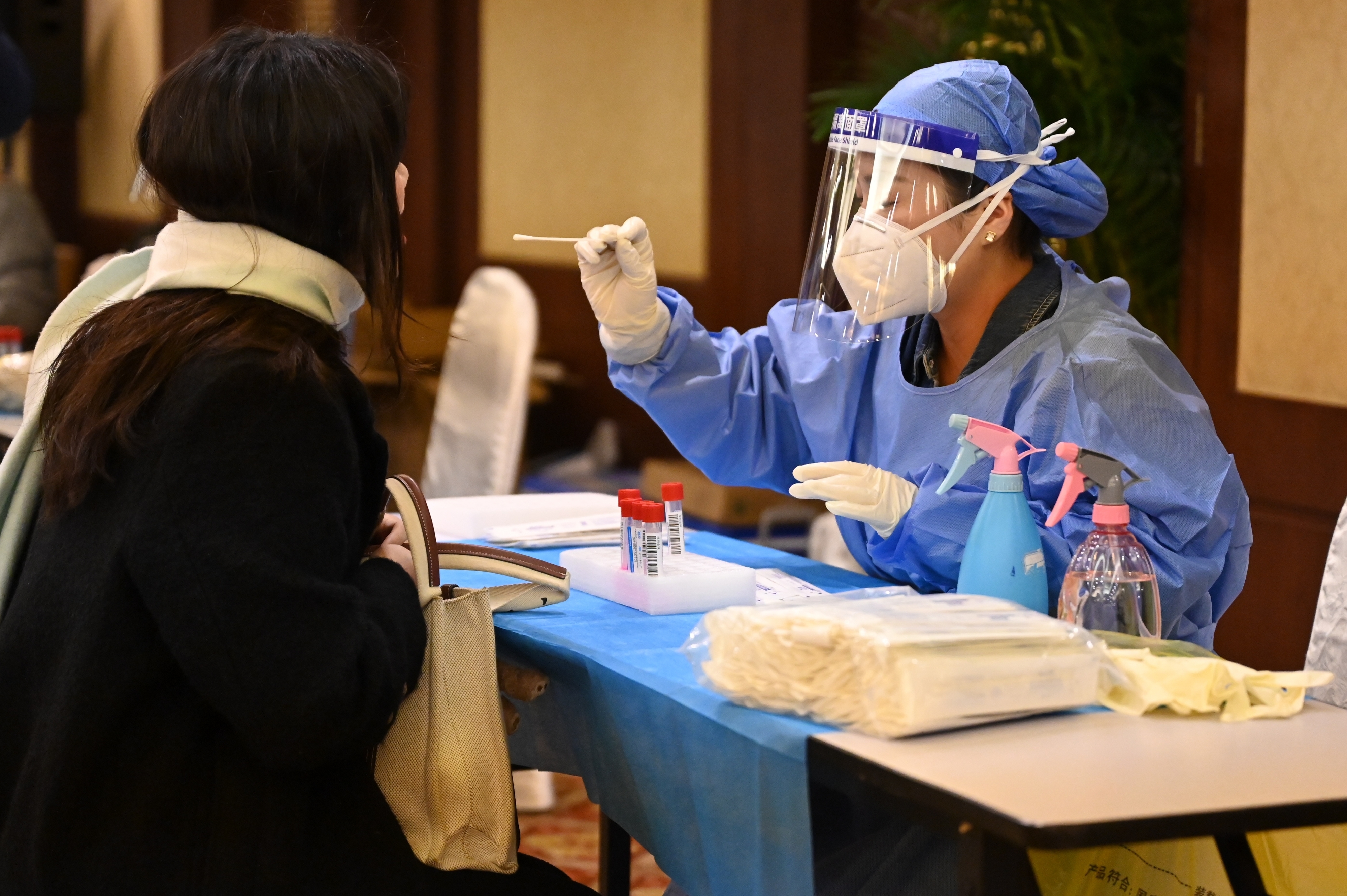 Health professional in PPE administering a nasal swab test to a person