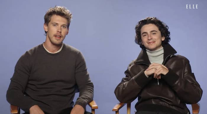 Timothée Chalamet and Austin Butler  seated side by side for an interview, one in a casual sweater, the other in a leather jacket