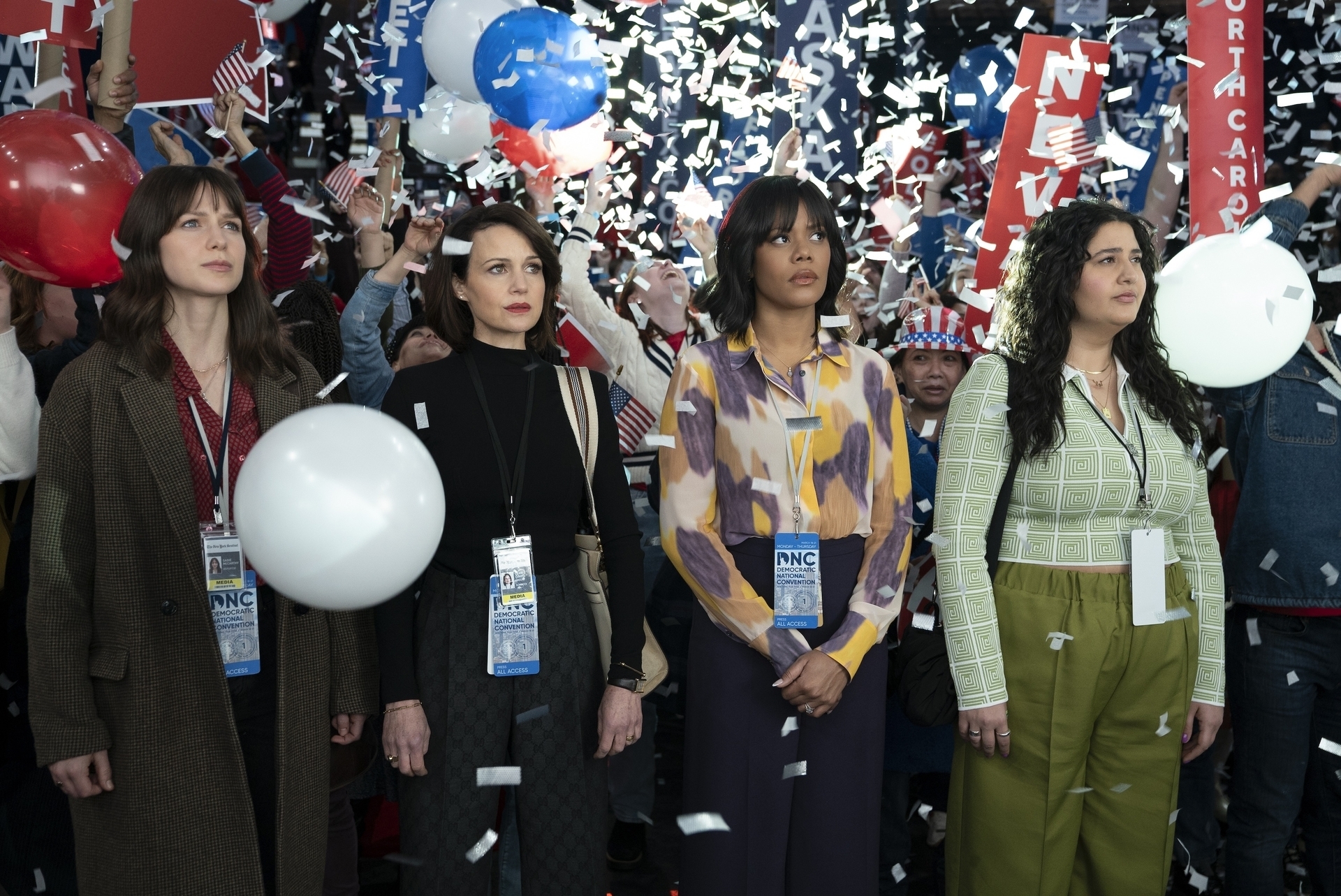 Four women at a political event with American flags and confetti. They are looking up, entranced