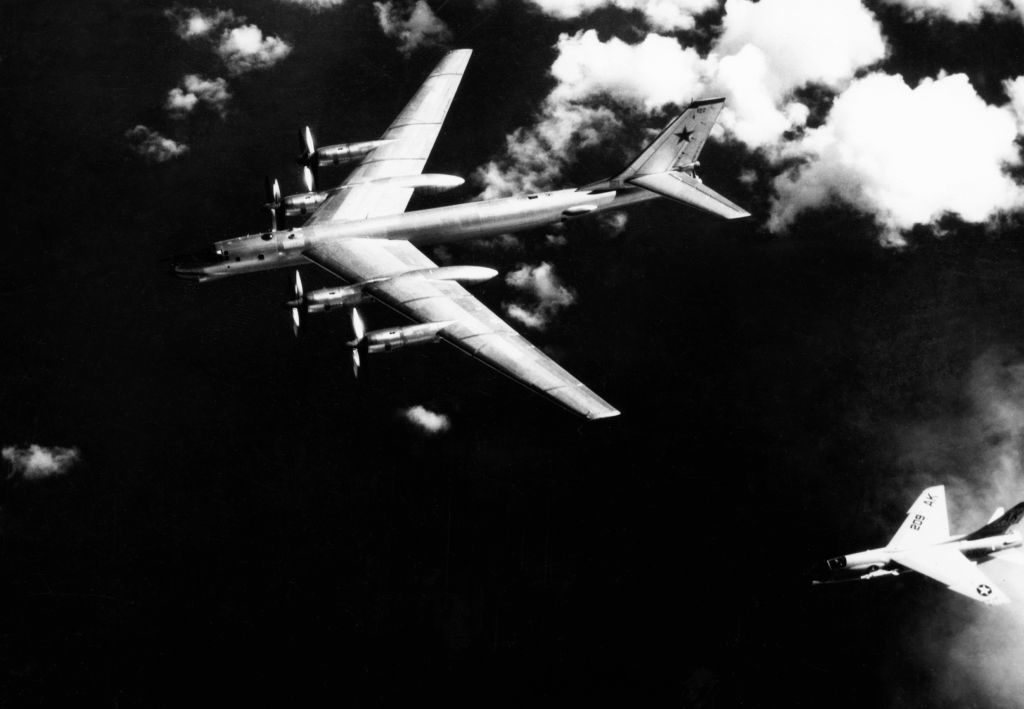 A Boeing B-52 Stratofortress flies in the sky with a jet escort