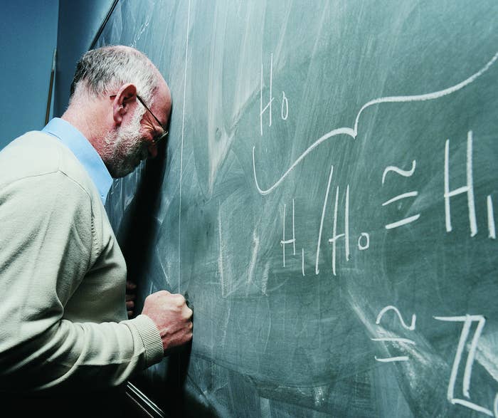 A teacher writing math on a chalkboard