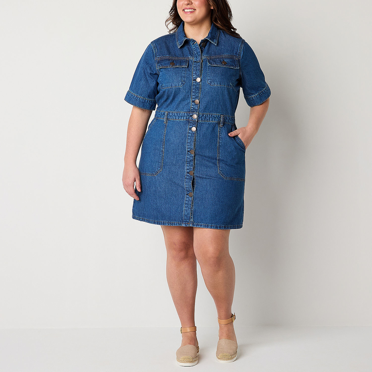 Woman in a collared denim dress with buttons and pockets, suitable for plus-size fashion options