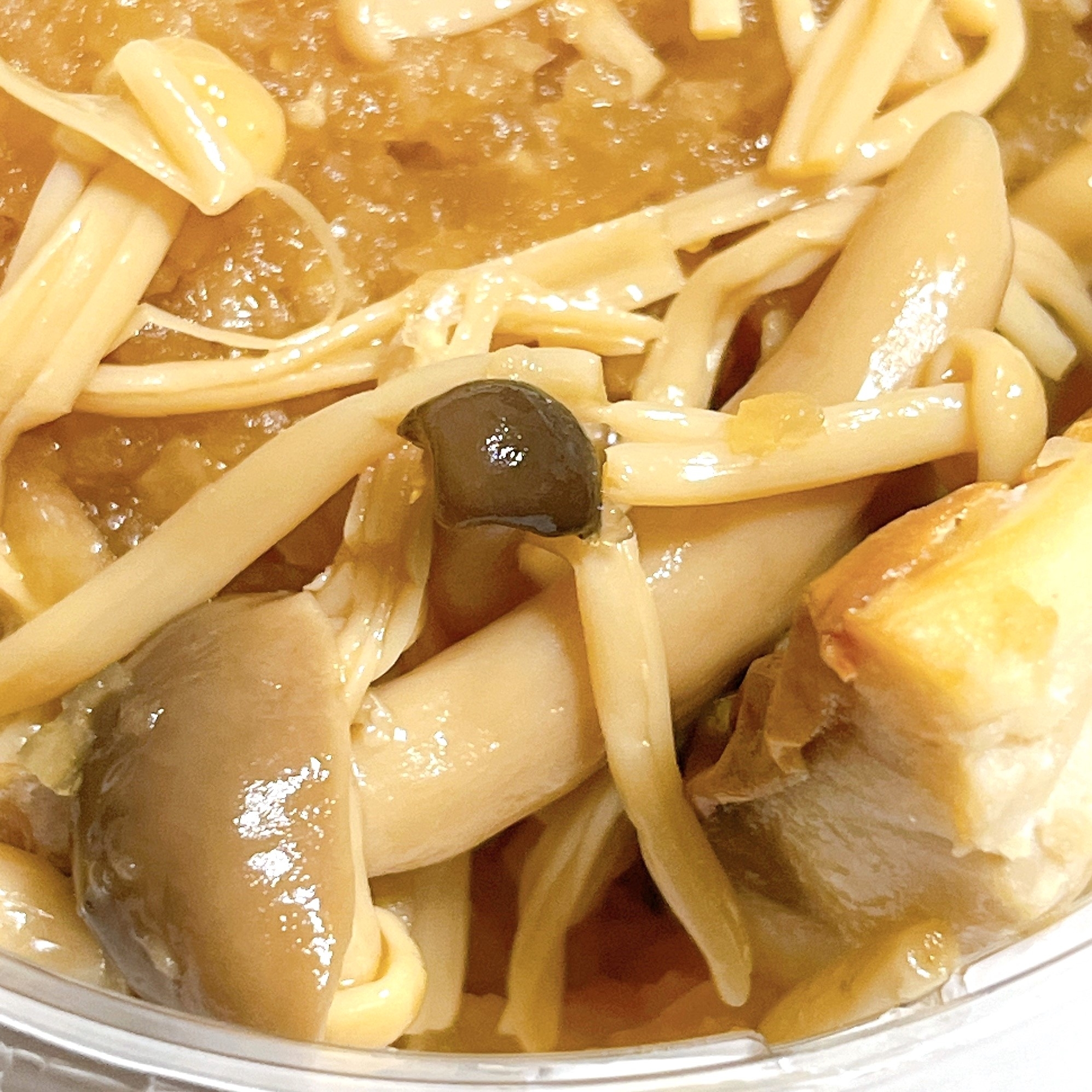 キノコと豚肉が入った煮物のクローズアップ写真です。