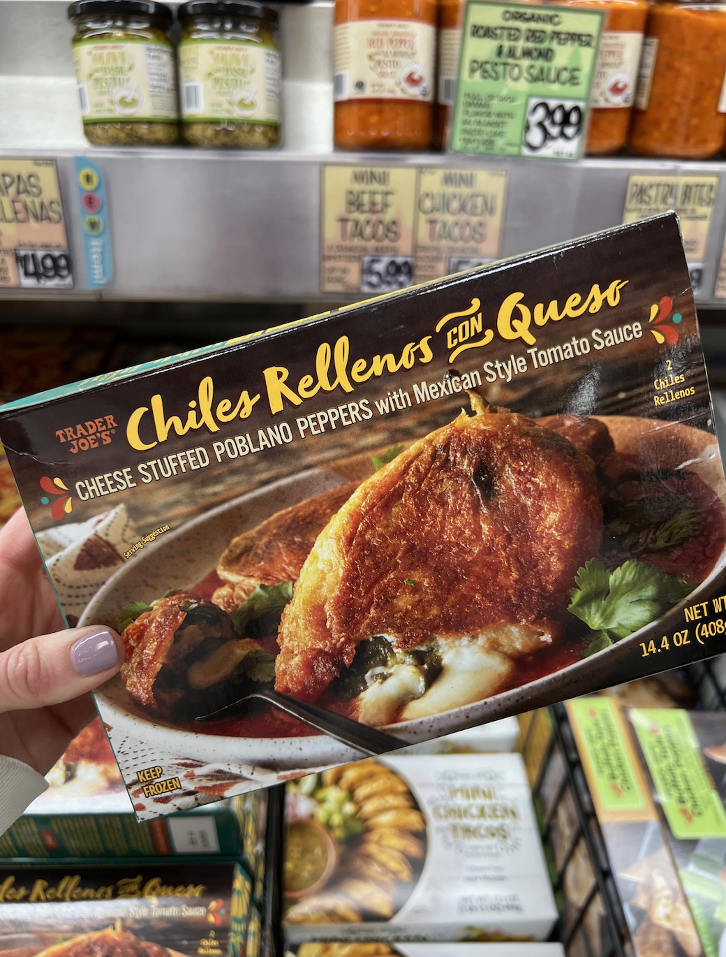 Hand holding a Trader Joe&#x27;s Chiles Rellenos con Queso package in a grocery store