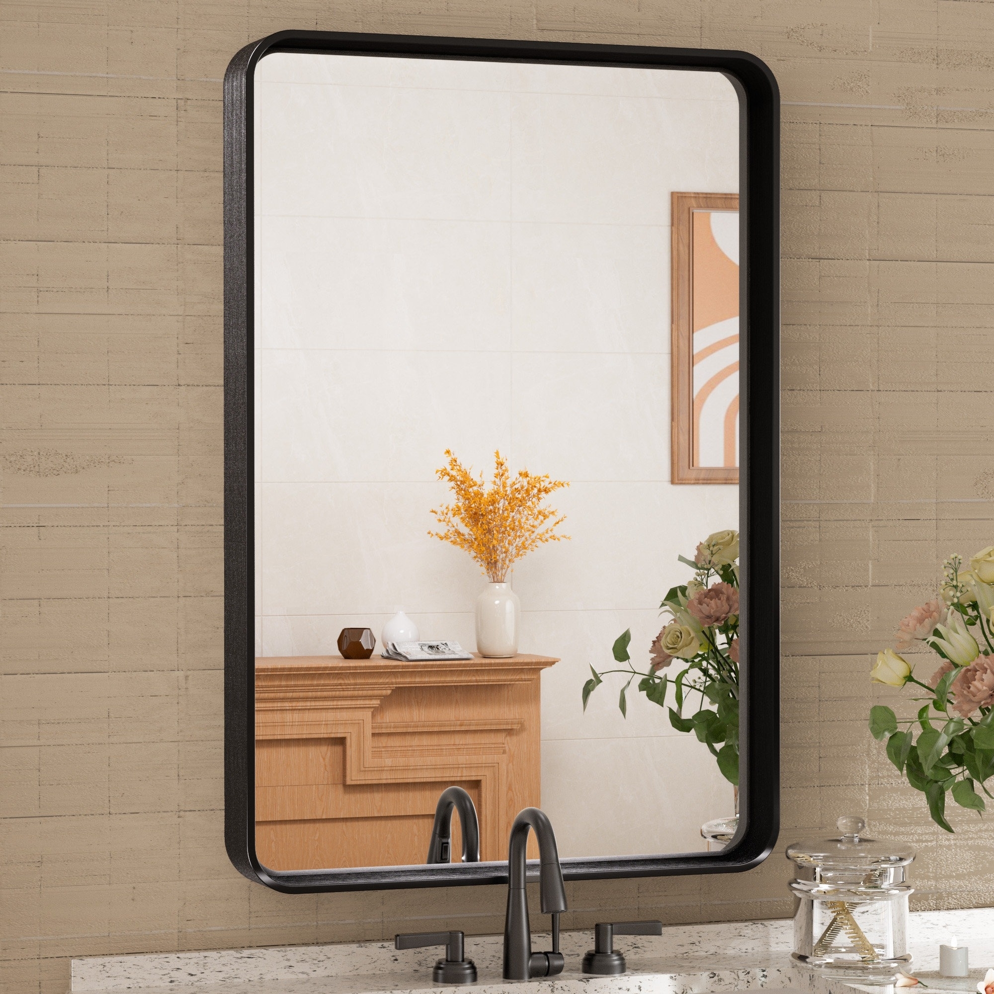 Wall mirror reflecting a bathroom vanity with a vase of yellow flowers and bathroom accessories