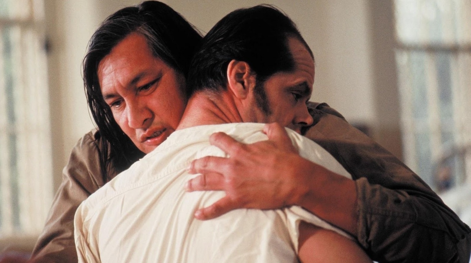 Two men embracing, one comforting the other, in a scene from a film