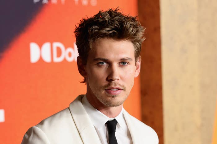 A close-up of Austin Butler in a suit jacket as he poses for the camera on the red carpet