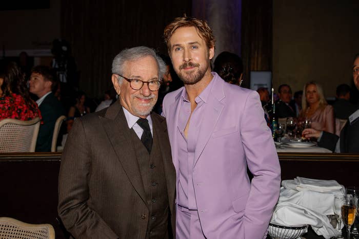 Steven Spielberg and Ryan Gosling posing together; Gosling in a light-colored suit, Spielberg in a dark suit
