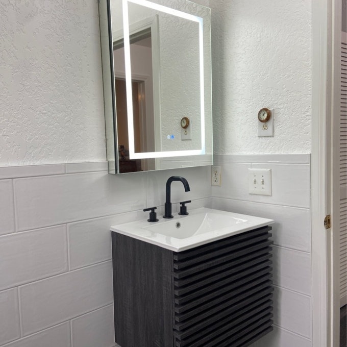 A modern bathroom vanity with a square sink and LED mirror, suitable for home renovation shopping
