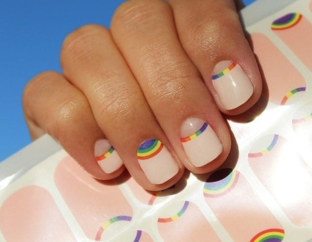 Close-up of a hand showcasing nails with minimalist rainbow nail art, reflecting a style available for purchase