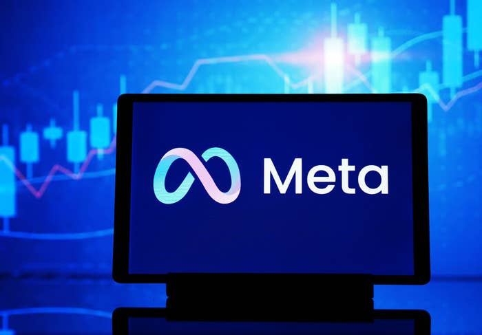 Meta logo displayed on a screen with graphical charts in the background